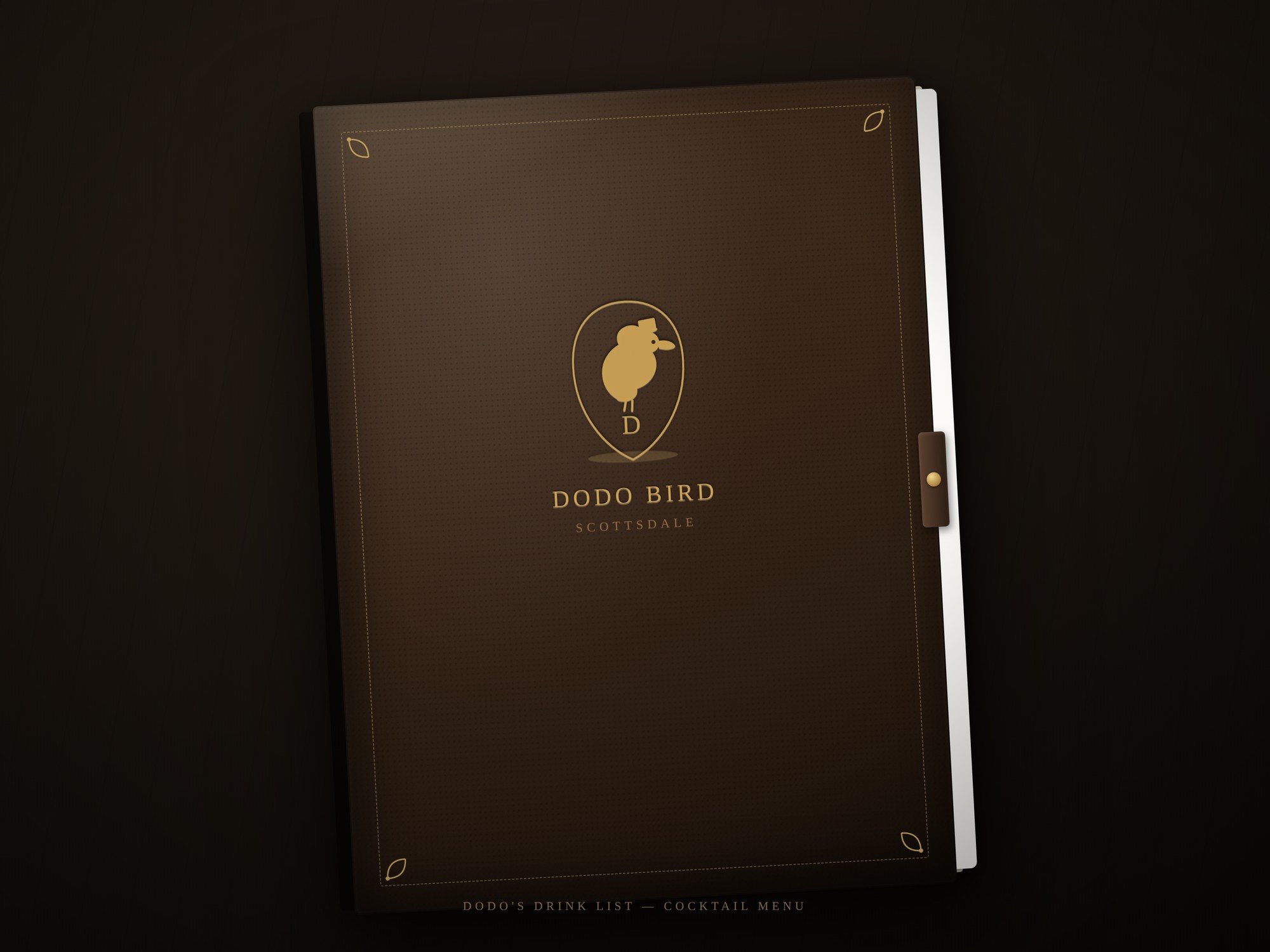 Mockup of the leather-bound DodoBird cocktail menu, embossed with a gold dodo crest